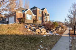 View of front of property featuring a garage and a balcony