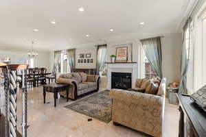 Living room with crown molding and a chandelier