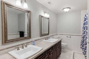 Bathroom featuring tile walls, vanity, tile patterned flooring, and toilet