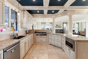 Kitchen with pendant lighting, sink, ornamental molding, kitchen peninsula, and stainless steel appliances