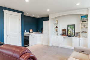 Interior space featuring light colored carpet, indoor wet bar, and wine cooler