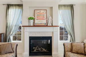 Sitting room featuring ornamental molding and a marble tiled fireplace