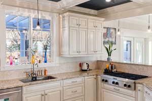 Kitchen featuring sink, crown molding, hanging light fixtures, stainless steel appliances, and light granite countertops