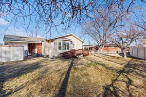 Rear view of house with a deck, and a lawn