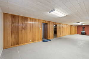 Basement featuring a wood stove and wooden walls