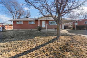 Ranch-style home with a front yard and a carport