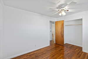 Unfurnished bedroom featuring ceiling fan, dark hardwood / wood-style flooring, and a closet