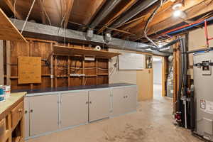 Basement featuring strapped water heater