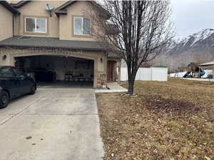 View of front facade with a garage and a mountain view