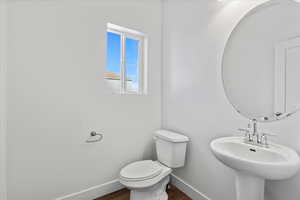 Bathroom with wood-type flooring, sink, and toilet
