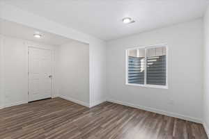 Unfurnished room with dark wood-type flooring