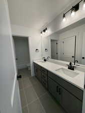 Full bathroom with vanity, a textured ceiling, tile patterned floors, toilet, and tiled shower / bath