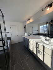 Bathroom with vanity, a bath, and a textured ceiling