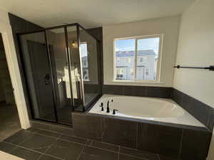 Bathroom with plus walk in shower and a textured ceiling