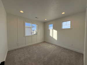 Carpeted empty room with a textured ceiling