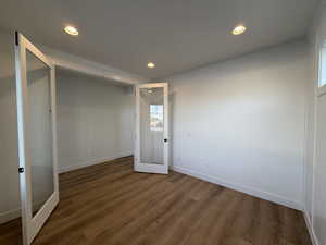 Unfurnished bedroom with hardwood / wood-style flooring and french doors