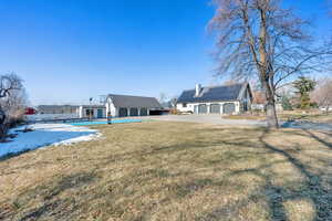 Back of house with a lawn and solar panels