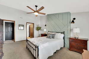 Carpeted bedroom featuring vaulted ceiling and ceiling fan