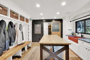 Mudroom with sink, crown molding, a barn door, and light wood-type flooring