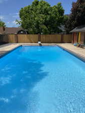 View of pool with a diving board and a patio