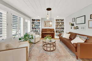 Living room with built in features and wood ceiling