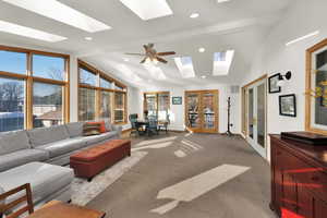 Living room with french doors, light colored carpet, and lofted ceiling with beams