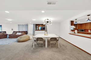 Dining area featuring carpet and a chandelier