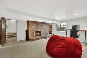 Living room with a brick fireplace and light colored carpet