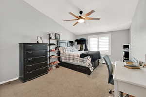 Bedroom with ceiling fan, carpet flooring, and vaulted ceiling