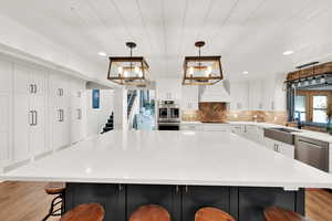 Kitchen with pendant lighting, sink, a breakfast bar area, appliances with stainless steel finishes, and a spacious island