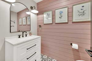 Bathroom with vanity and wood walls