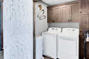 Washroom featuring cabinets and washing machine and dryer