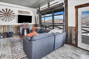 Living room with light wood-type flooring and wood walls