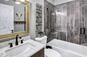 Full bathroom featuring vanity, toilet, and tiled shower / bath combo