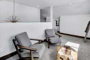 Living area featuring lofted ceiling and carpet