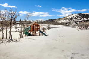 Snow covered playground featuring a mountain view