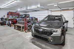 Garage featuring a garage door opener and a workshop area