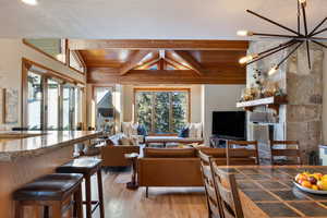 Living room with vaulted ceiling with beams, plenty of natural light, light hardwood / wood-style floors, and wooden ceiling