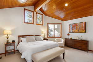 Bedroom featuring light carpet, wood ceiling, and vaulted ceiling