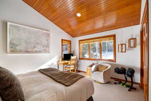 Bedroom with carpet flooring, vaulted ceiling, and wooden ceiling