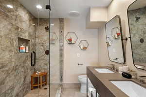 Bathroom featuring vanity, toilet, and a shower with shower door