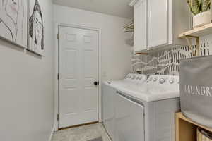 Laundry room with cabinets and washer and dryer