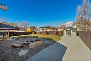 View of yard with a gazebo, a patio, an outdoor fire pit, a storage unit, and a mountain view