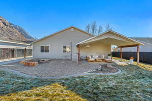 Back of property with a mountain view, outdoor lounge area, a yard, and a patio area