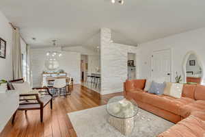 Living room with lofted ceiling and light hardwood / wood-style flooring