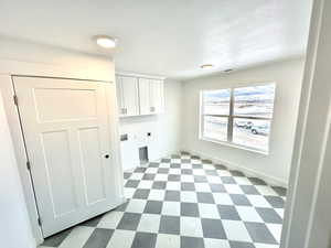 Second floor laundry room featuring cabinets, and closet.