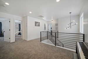 Hall with a notable chandelier and carpet flooring