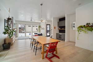 Dining room featuring ceiling fan, beverage cooler, and light wood-type flooring