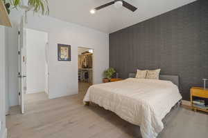 Bedroom featuring ceiling fan, a spacious closet, light hardwood / wood-style floors, and a closet