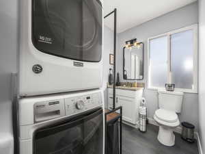 Laundry room with stacked washer and dryer and sink